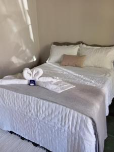 a white bed with towels on top of it at Chalé da Lili in Nova Friburgo