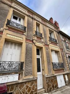 an old building with white doors and windows at La Pause - 15m2 - central - proche parking in Auxerre