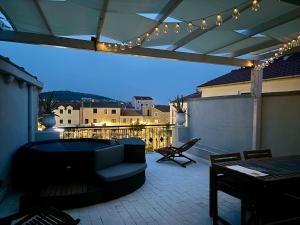 a patio with a couch and a table and lights at Apartmani Agora in Betina