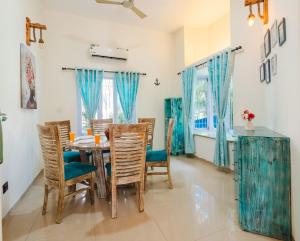 a dining room with a table and chairs at Villa Sylvana By Bluewave Hospitality in Nagoa-Bardez