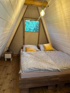 a bedroom with a bed in a attic with a window at Chata Triangel Komjatná in Komjatná