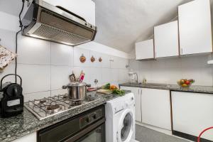 a kitchen with a stove and a washing machine at Il Balcone Sulle Alpi ski in ski out - Happy Rentals in Sauze d'Oulx