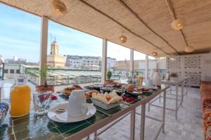 a table with food and drinks on a balcony at Riad Al Mozyane in Fez