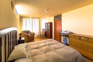 a bedroom with a bed and a desk and a chair at Namaste Bnb in Yanahuara