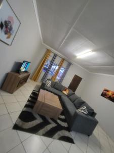 a living room with a couch and a table at Nestville apartments in Solwezi +2 photos