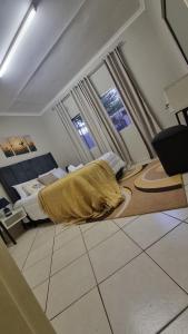 a bedroom with a bed and two windows at Nestville apartments in Solwezi