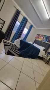 a couch in a living room with blue curtains at Nestville apartments in Solwezi