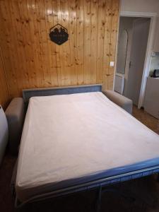 艾尔比蒙通Appartement au pied des pistes的带木墙的房间里的一张床 更多10张照片