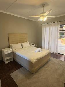 a bedroom with a bed and a ceiling fan at Mitchell Guest House Golf Road in Pietermaritzburg