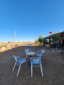 a group of chairs and a table in a field at Camping Meteorite in Merzane +14 photos