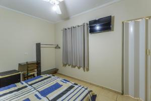 a bedroom with a bed and a tv on the wall at Hotel do Museu no ipiranga com TV ventilador banheiro in São Paulo +35 photos
