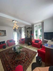 a living room with red couches and a rug at Maison spacieuse avec jardin à Cabourg, 250 m² in Cabourg