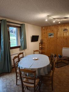 艾尔比蒙通Appartement au pied des pistes的一间有桌子、椅子和窗户的餐厅