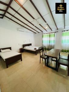 a room with two beds and a table and chairs at Golden Kingdom Hotel in Kandy