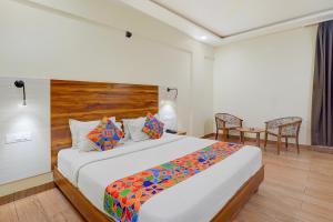 Un dormitorio con una cama grande con cabecero de madera. en FabHotel East Land, en Bangalore
