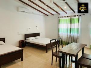 a room with a bed and a table and chairs at Golden Kingdom Hotel in Kandy