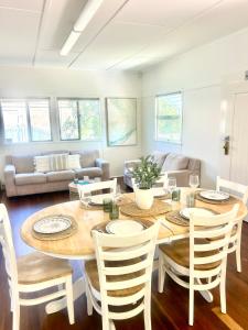 a living room with a wooden table and chairs at Seeside Cottage - See St Bargara in Bargara +16 photos