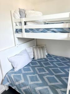 two bunk beds in a room with a blue mattress at Seeside Cottage - See St Bargara in Bargara