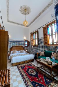 a bedroom with a bed and a couch in a room at Riad Al Mozyane in Fez