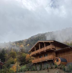 une cabane dans les montagnes d'où s'échappe de la fumée dans l'établissement Somptueux Chalet 12 personnes - Villaroger, à Villaroger