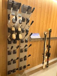 un mur recouvert de gants et de crosses de hockey dans l'établissement Somptueux Chalet 12 personnes - Villaroger, à Villaroger