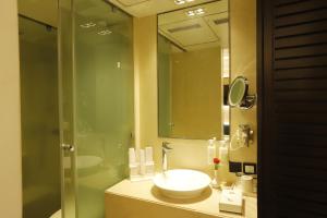 ムンバイにあるザ サヒール ホテルの洗面台とガラスのシャワーを備えたバスルーム +28枚の写真