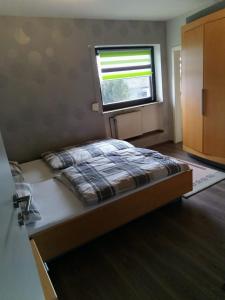 a bedroom with a bed and a window at Panoramablick Donnersberg in Dannenfels