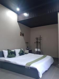 NongkhiawVinla Guesthouse & Backpackers Hostel的卧室里有一张白色的大床，上面放着绿色的枕头 更多18张照片