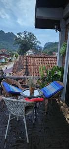 NongkhiawVinla Guesthouse & Backpackers Hostel的一个带两张桌子和两把椅子的露台，还有一个屋顶。
