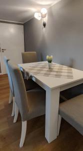 einen weißen Tisch mit Stühlen und eine Vase mit Blumen darauf in der Unterkunft Chalet am Diemelsee - Ferienwohnung mit Terrasse im Sauerland in Heringhausen