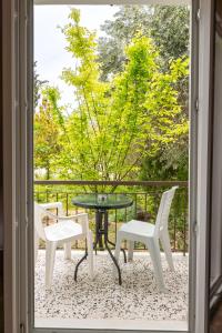 a patio with two chairs and a table and chairs at Ulrika in Aegina Town