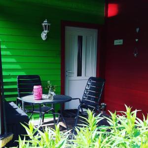 a table and two chairs outside of a green house at Ferienwohnung Sonneneck mit Boot und Kanu in Seedorf