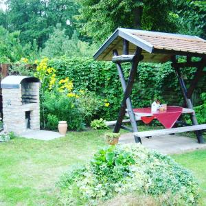 a picnic table in a gazebo in a garden at Ferienwohnung Sonneneck mit Boot und Kanu in Seedorf