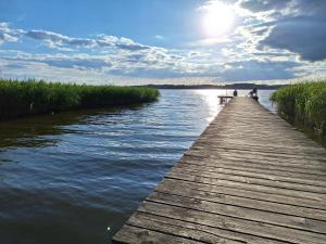 a wooden bridge over a river with the sun in the sky at Ferienwohnung Sonneneck mit Boot und Kanu in Seedorf +3 photos