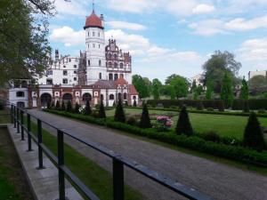 a large white building with a clock tower on top at Ferienwohnung Sonneneck mit Boot und Kanu in Basedow +3 photos