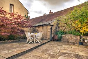a patio with a table and chairs in front of a building at Finest Retreats - Morley House in Lechlade