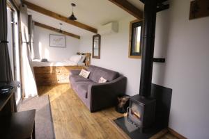 a living room with a wood stove and a couch at 1 Bed Hut - Sleeps 4 - Pets - Parking in Minehead