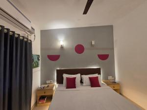 a bedroom with a large bed with red pillows at Baga Waves by Dia Hotels And Homes in Calangute