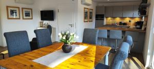 a dining room table with a vase of flowers on it at Chalet am Diemelsee mit Seeblick im Sauerland in Heringhausen