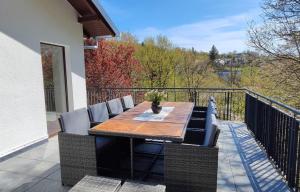 a deck with a wooden table and chairs on a balcony at Chalet am Diemelsee mit Seeblick im Sauerland in Heringhausen