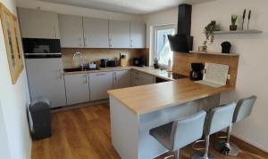 a kitchen with white cabinets and a wooden counter top at Chalet am Diemelsee mit Seeblick im Sauerland in Heringhausen