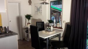 a dining room with a white table and black chairs at Ferienwohnung am Malchiner See mit Boot und Kanu in Seedorf