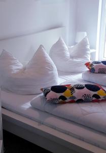 two pillows on a bed with white pillows at Ferienwohnung am Malchiner See mit Boot und Kanu in Seedorf