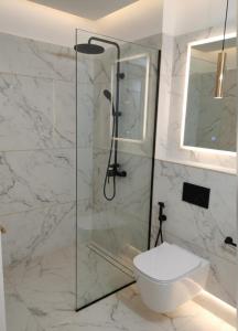 a bathroom with a toilet and a glass shower at Chatnya Homes Kasauli by Splendid Hotels - Family Groups Events in Kasauli