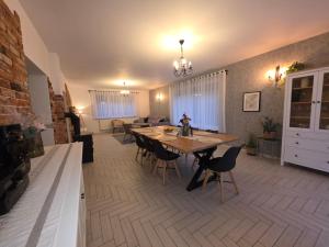 a kitchen and dining room with a table and chairs at Komfortowy Dom Całoroczny - sauna, jacuzzi, bilard in Tyłowo