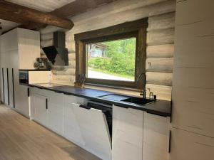 a kitchen with a sink and a window at Zrub House Карпати in Rozhanka Nizhnyaya