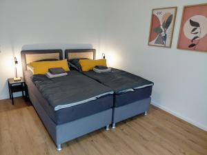 HalverにあるWestfalio Apartments - BrightStay Halver - feel at homeの黄色い枕が置かれたベッドのある寝室