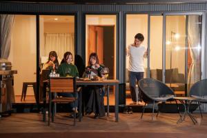 a group of people sitting at a table in a room at Villas Fuji Terrace ヴィラス富士テラス in Fujikawaguchiko