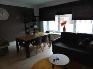 een woonkamer met een zwarte bank en een tafel bij Henry in Schiffweiler