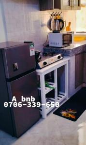 a small kitchen with a refrigerator and a stove at Tulivu Homes in Meru